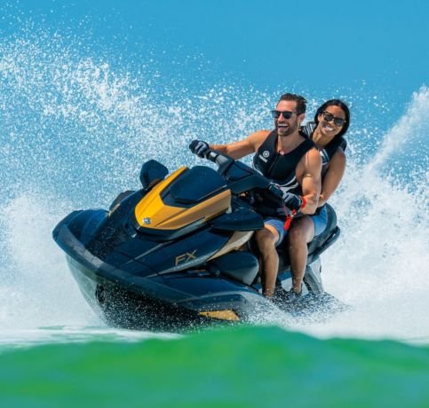 Couple riding a jet ski on clear blue water